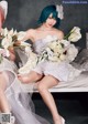 A couple of women sitting on top of a bed holding flowers.