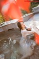 A woman in a white dress sitting in a pool of water.